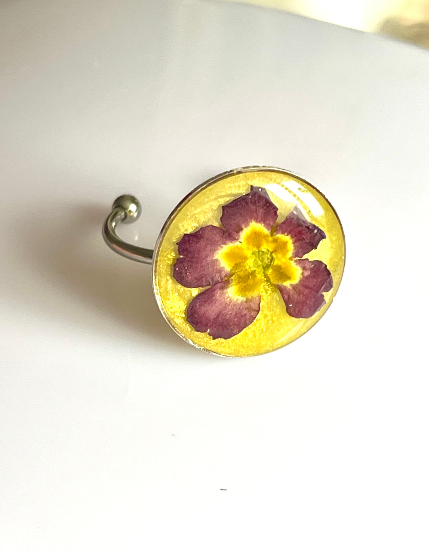 Bague fleur de primevère violette fond jaune